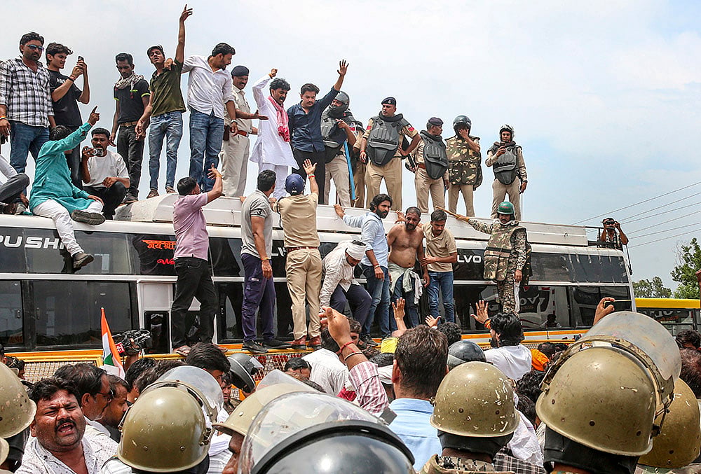 | Photo: PTI : Farmers climb atop a bus as they stage a protest to press for various demands, including 100 per cent moong procurement at MSP, in Bhopal, Madhya Pradesh, Wednesday, July 29, 2026. 