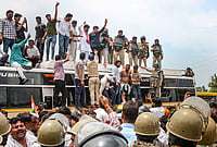 | Photo: PTI : Farmers climb atop a bus as they stage a protest to press for various demands, including 100 per cent moong procurement at MSP, in Bhopal, Madhya Pradesh, Wednesday, July 29, 2026. 