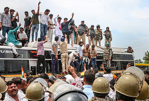 Farmers climb atop a bus as they stage a protest to press for various demands, including 100 per cent moong procurement at MSP, in Bhopal, Madhya Pradesh, Wednesday, July 29, 2026. 