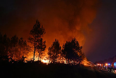 Firefighters battle a blaze outside Lanton, during wildfires in southwestern France.