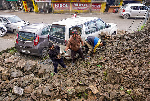 People remove debris after a retaining wall collapsed following heavy monsoon rainfall, in Shimla, Himachal Pradesh,.