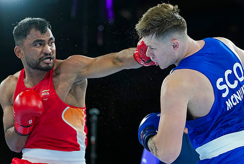 India's Kapil Pokhariya, in red, competes against Scotland's Robert McNulty during the men's 90kg boxing match at the 23rd Commonwealth Games, in Glasgow, Scotland.