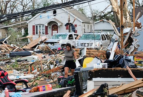 A woman walks among debris after a tornado struck in Menasha, Wisconsin.
