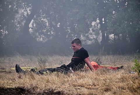 A firefighter takes a break after battling fires near La Haouteyre, during wildfires in southwestern France, Wednesday, July 29, 2026. 