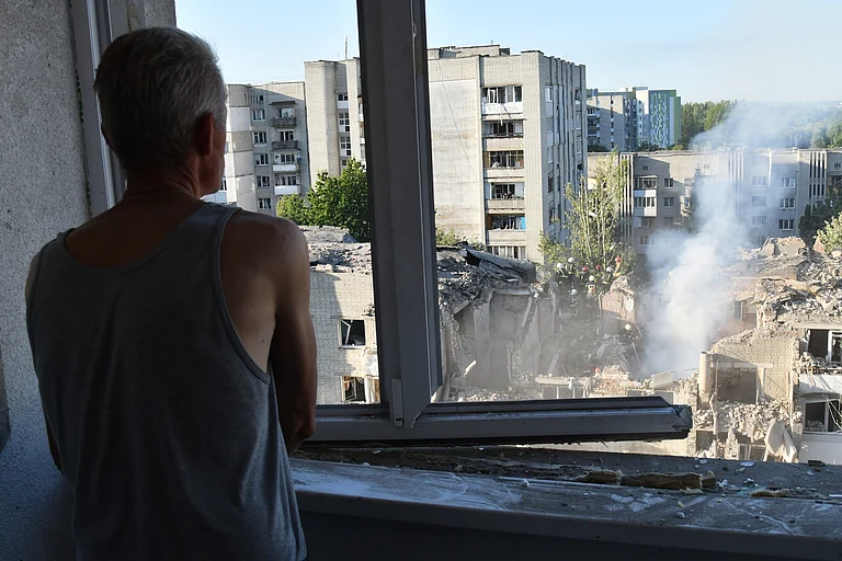 A man watches as rescuers clear the rubble at the damaged apartment building in a residential neighbourhood following a Russian air attack in Lviv, Ukraine, Thursday, July 30, 2026. - Mykola Tys