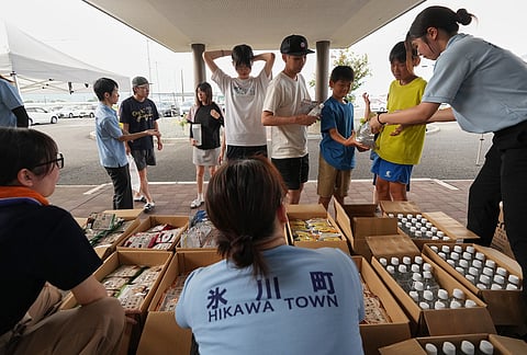 Residents receive food supply, following an earthquake in Hikawa, Kumamoto Prefecture, southern Japan, Thursday, July 30, 2026. 