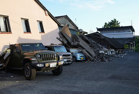 Vehicles are crushed under collapsed buildings in Yatsushiro, southwestern Japan, Wednesday, July 29, 2026, the day after an earthquake hit the area. 
