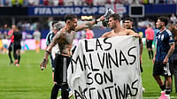 FIFA Charges Argentina Over World Cup Final Clash, Malvinas Banner Controversy (AP Photo/Rebecca Blackwell) : Argentina's Giovani Lo Celso holds a banner with the words "The Malvinas are Argentine", referring to the Falkland Islands, while teammate Argentina's Nicolas Otamendi gestures to him, at the end of the World Cup semifinal soccer match between England and Argentina in Atlanta, Wednesday, July 15, 2026.