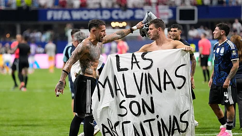 (AP Photo/Rebecca Blackwell) : Argentinas Giovani Lo Celso holds a banner with the words The Malvinas are Argentine, referring to the Falkland Islands, while teammate Argentinas Nicolas Otamendi gestures to him, at the end of the World Cup semifinal soccer match between England and Argentina in Atlanta, Wednesday, July 15, 2026.