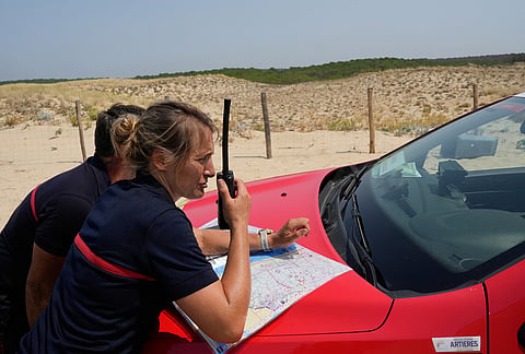 Fire personnel look at a map as they locate fire zones near Ares, during wildfires in southwestern France, Wednesday, July 29, 2026.