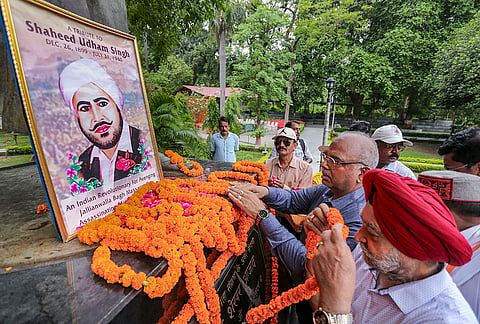 People pay floral tribute to the portrait of freedom fighter Shaheed Udham Singh on his death anniversary at Amar Shaheed Chandrashekhar Azad Park, in Prayagraj, Uttar Pradesh.