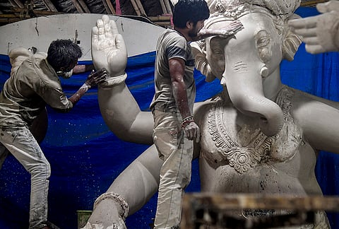 Artisans work on an idol of Lord Ganesh amid preparations for the upcoming 'Ganesh Chaturthi' festival, in Mumbai, Maharashtra.