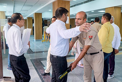 A police official conducts a security check after District and Sessions Court and the Mini Secretariat received email bomb threats, in Gurugram, Haryana.