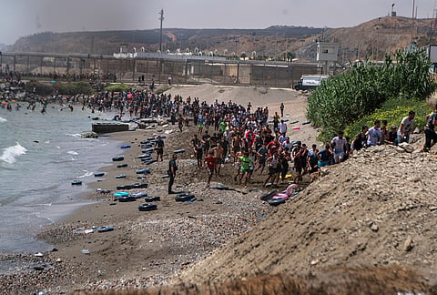 Migrants cross from Morocco into the Spanish enclave of Ceuta, Thursday, July 30, 2026. 