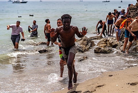 Migrants cross from Morocco into the Spanish enclave of Ceuta, Thursday, July 30, 2026. 