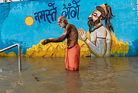 | Photo: PTI : A sadhu offers prayers in the submerged section of Dashashwamedh Ghat after the water level of Ganga river rises, in Prayagraj, Uttar Pradesh.