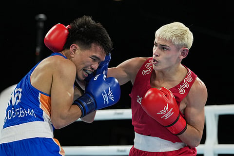 Australia's Jye Dixon, right, and India's Jadumani Singh Mandengbam compete in the men's 55kg boxing final at the Commonwealth Games in Glasgow, Scotland.