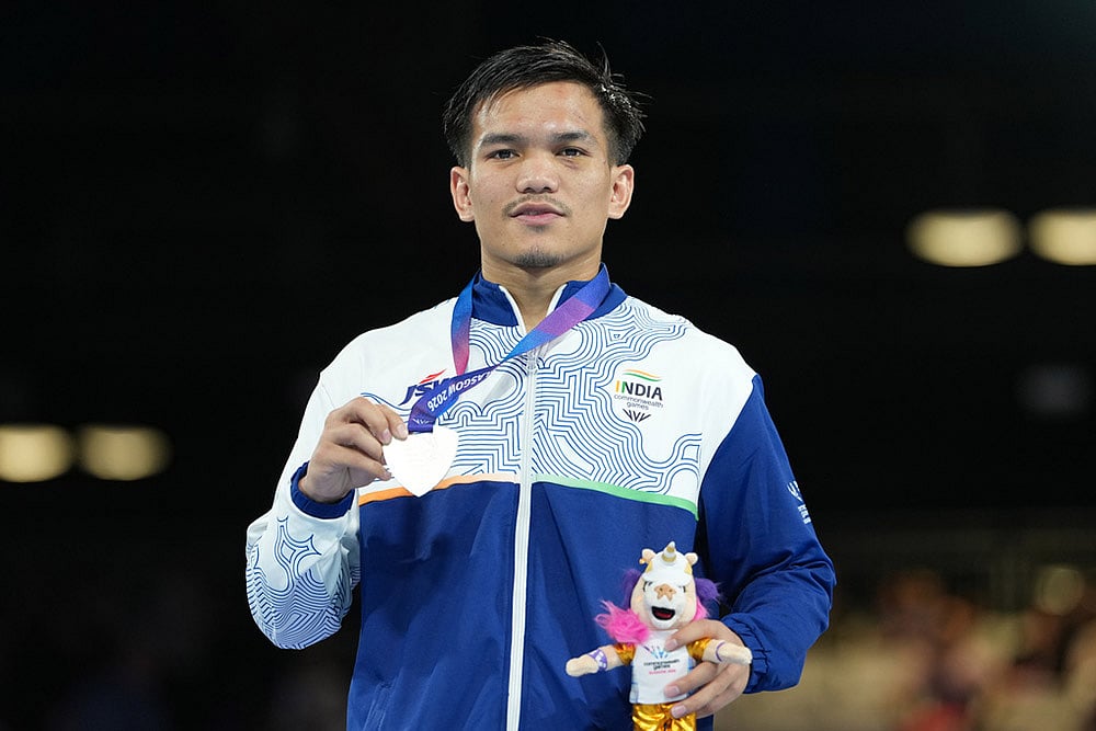 Silver medalist India's Jadumani Singh Mandengbam celebrates after winning the men's 55kg boxing final at the Commonwealth Games in Glasgow, Scotland. - | Photo: AP/Eranga Jayawardena