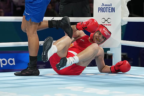 India's Arundhati Choudhary falls as she competes with England's Chantelle Reid in the women's 70kg boxing final at the Commonwealth Games in Glasgow, Scotland
