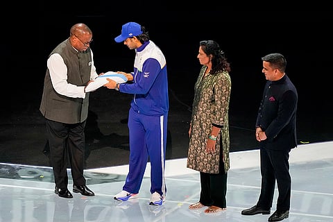 Commonwealth Sport President Donald Rukare, left, hands over the Commonwealth Games Federation flag to Indian javelin thrower Neeraj Chopra, second left, during the closing ceremony of the 23rd Commonwealth Games (CWG), at OVO Hydro, in Glasgow, Scotland. Indian Olympic Association (IOA) President P T Usha, second right, and Gujarat Deputy Chief Minister Harsh Sanghavi are also seen. 