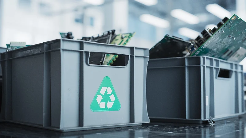 Electronic waste in gray recycling bins