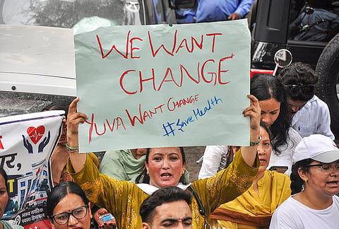 A woman holds a placard during a protest demanding justice following the death of a woman after childbirth at the Regional Hospital, in Kullu, Himachal Pradesh.
