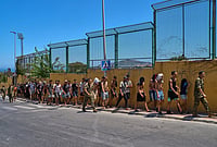 | Photo: AP/Bernat Armangue : Migrants who crossed into Spain are escorted by Spanish soldiers toward the Spanish-Moroccan border for their return to Morocco from the Spanish enclave of Ceuta, Sunday, Aug. 2, 2026. 