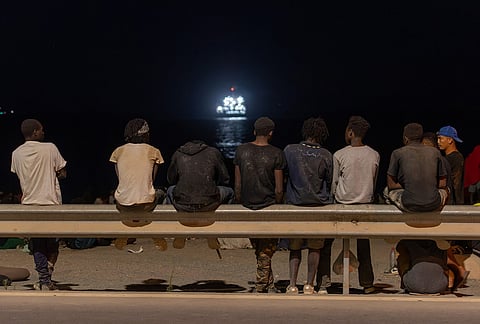 Migrants who crossed into Spain from Morocco gather on a beach in the Spanish enclave of Ceuta, Sunday, Aug. 2, 2026. 