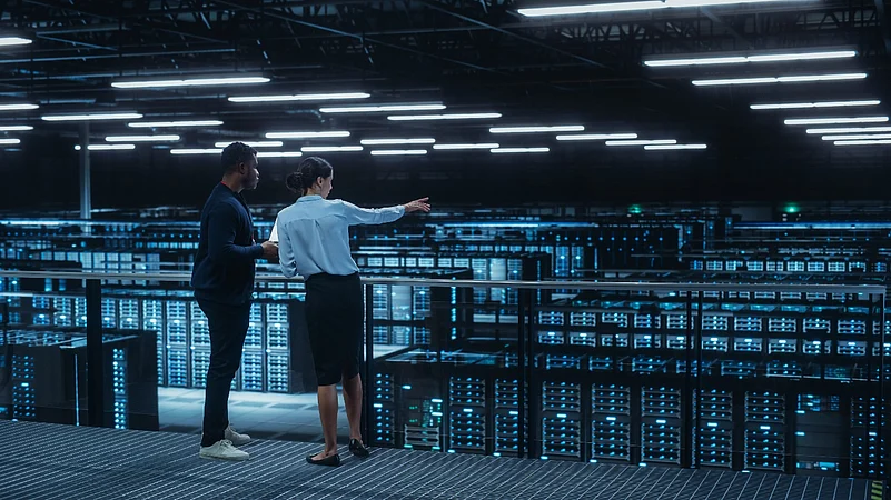 Two engineers overlooking a large data center
