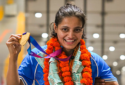 Judo gold medallist Asmita Dey poses on her arrival after the Glasgow Commonwealth Games, at IGI Airport in New Delhi, early Tuesday, Aug. 4, 2026. 