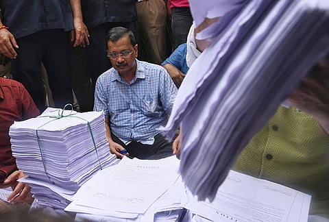 Aam Aadmi Party leader Arvind Kejriwal sits beside bundles of petitions signed in opposition to the government's E20 fuel policy during a protest in New Delhi, India, Tuesday, Aug. 4, 2026. 