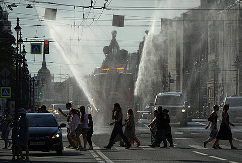 A truck sprays water during a hot day in central St. Petersburg, Russia, Friday, July 31, 2026. 