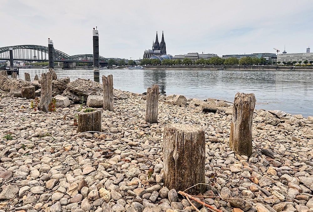 | Photo:  AP/Martin Meissner : Remains of the post-World War II Patton Bridge are exposed during historically low water levels of the Rhine River during a heat wave and a prolonged drought, across from the Cologne Cathedral in Cologne, Germany, Monday, Aug. 3, 2026.
