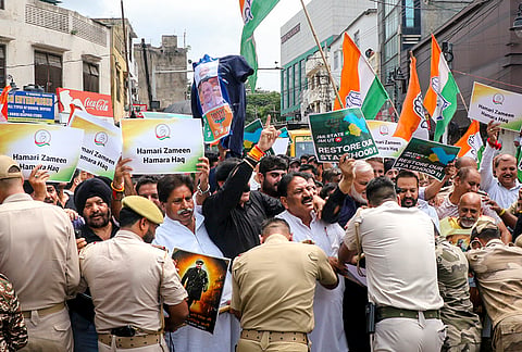Police personnel stop Jammu and Kashmir Pradesh Congress (JKPC) Working President Raman Bhalla and other party workers after they take out a protest rally on the seventh anniversary of the abrogation of Article 370, demanding the restoration of the special status of the erstwhile state of Jammu and Kashmir, in Jammu, Wednesday, Aug. 5, 2026. 