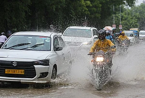 | Photo: PTI : Commuters move through heavy monsoon rain, in Prayagraj, Uttar Pradesh.