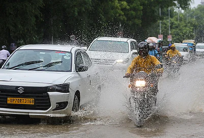 | Photo: PTI : Commuters move through heavy monsoon rain, in Prayagraj, Uttar Pradesh.