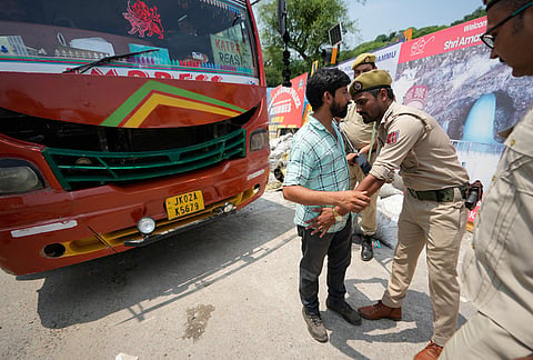 A Jammu and Kashmir police officer frisks passengers as the security grid in Jammu and Kashmir is placed on high alert ahead of the seventh anniversary of the abrogation of Article 370 of the Constitution, in Jammu, Tuesday, Aug 4, 2026.