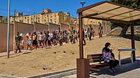 | Photo: AP/Bernat Armangue : A Ceuta resident sits at a bus station as migrants who crossed into Spain are escorted by Spanish soldiers toward the Spanish-Moroccan border, for their return to Morocco from the Spanish enclave of Ceuta, Sunday, Aug. 2, 2026. 