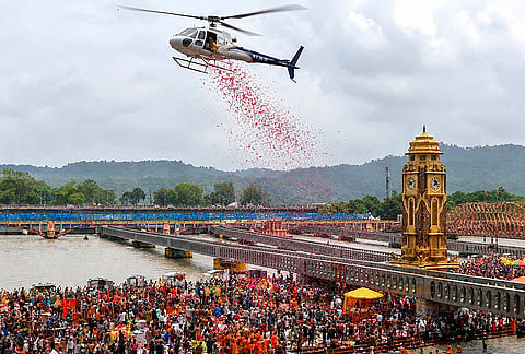 A helicopter showers flower petals over Kanwariyas gathered at Har Ki Pauri during the annual Sawan Kanwar Yatra, in Haridwar, Tuesday, Aug. 4, 2026. 