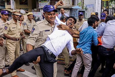 A police official detains a Akhil Bharatiya Vidyarthi Parishad (ABVP) supporter during a protest demanding solutions to long-pending student grievances, at Telangana Board of Intermediate Education (TSBIE) office, in Hyderabad.