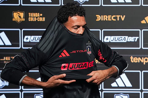 Cape Verde goalkeeper Vozinha puts on his new Colo Colo jersey during his presentation as a new player at Monumental stadium in Santiago, Chile.