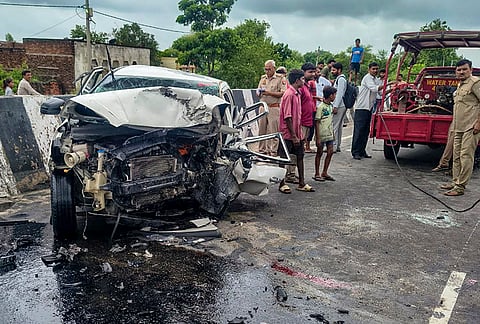 Security personnel and people gather near the wreckage of a car after it crashed into a divider, in Jhansi, Uttar Pradesh. Aban Ahmad, the youngest son of slain gangster-turned-politician Atiq Ahmad, and his friend were killed. 