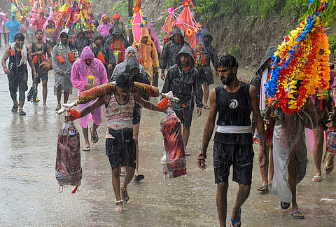 'Kanwariyas’ carry water from the Ganga river amid rain as part of ‘Kanwar Yatra’ during the month of ‘Shravan’, in Haridwar.