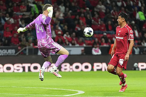 Stefan Frei goalkeeper of The United States Seattle Sounders FC, left, and Edgar Lopez of Mexico's Toluca compete for the ball during a Leagues Cup soccer match in Toluca, Mexico.