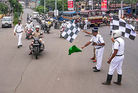A traffic official flags off a motorcycle rally led by Deputy Commissioner of Police (DCP) Sambhav Jain, Traffic, to promote traffic awareness as part of the Road Safety Week 2026, at Howrah Bridge, in Kolkata.