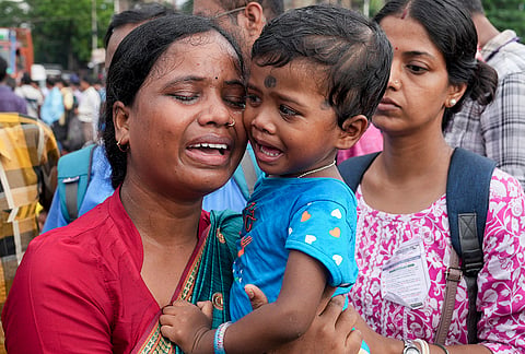 A protester with her child breaks down as eligible and untainted teachers and job aspirants from the 2016 State Level Selection Test (SLST) batch stage a peaceful sit-in demonstration, demanding justice, job security and the immediate release of segregated lists, at Esplanade in Kolkata.