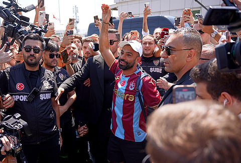Egypt's Mohamed Salah wearing his new Trabzonspor team jersey gestures to supporters as he arrives at the airport in Istanbul, Turkey, Wednesday, Aug. 5, 2026. 