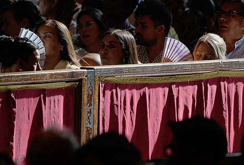 Faithful use their fan to cool-off as they wait for the arrival of Pope Leo XIV n the occasion of the weekly general audience in St. Peter's Basilica, at the Vatican, Wednesday, Aug. 5, 2026. 