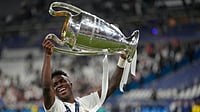 (AP Photo/Kirsty Wigglesworth, File) : FILE - Real Madrid's Vinicius Junior holds up the trophy after winning the Champions League final soccer match between Liverpool and Real Madrid in Saint Denis near Paris, May 29, 2022.