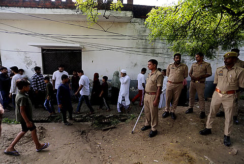Police personnel stand guard as relatives gather outside the residence after the body of Aban Ahmad, the youngest son of slain gangster-turned-politician Atiq Ahmad, arrives following a road accident in Jhansi, in Prayagraj, Uttar Pradesh.